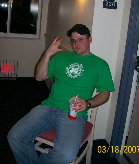 1990 Ford Bronco - A man wearing a green t-shirt and jeans sits holding a drink, with a room number sign visible in the background.
