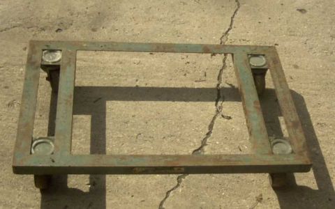 1997 Ford Taurus - A green metal engine stand rests on a cracked concrete surface.