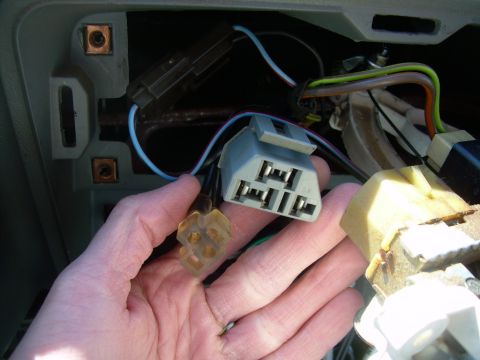 1988 Ford Bronco - Close-up of vehicle wiring harness connectors being held in a hand.
