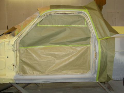 1967 Ford Ranchero - A car door is covered in masking paper and tape, likely in preparation for painting.