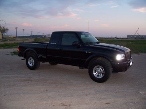 2003 Ford Ranger - A black 2003 Ford Ranger Edge pickup truck is parked on a dirt road during twilight.