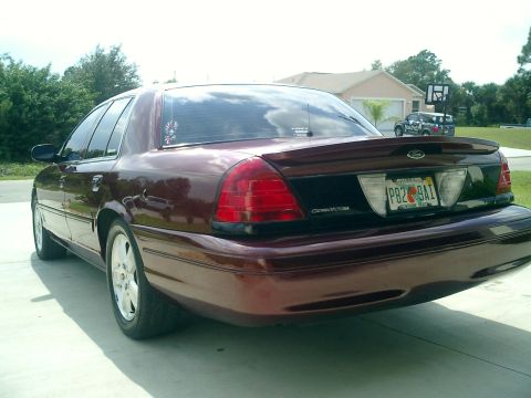 2004 Ford Crown Victoria - Rear view of a maroon 2004 Ford Crown Victoria parked in a driveway.