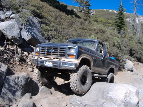 1986 Ford Bronco - This Ford Bronco navigates a challenging rocky trail with its front end angled towards the viewer.