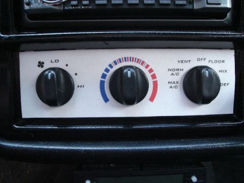 1992 Ford Crown Victoria - Close-up of the climate control panel, three rotary knobs for adjusting fan speed, temperature, and air distribution.