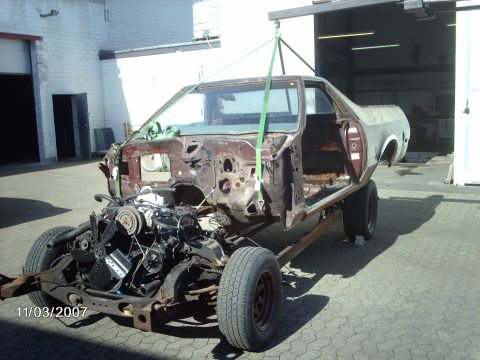 1979 Ford Ranchero - This vehicle body is suspended by straps from an overhead crane, revealing its chassis and engine.