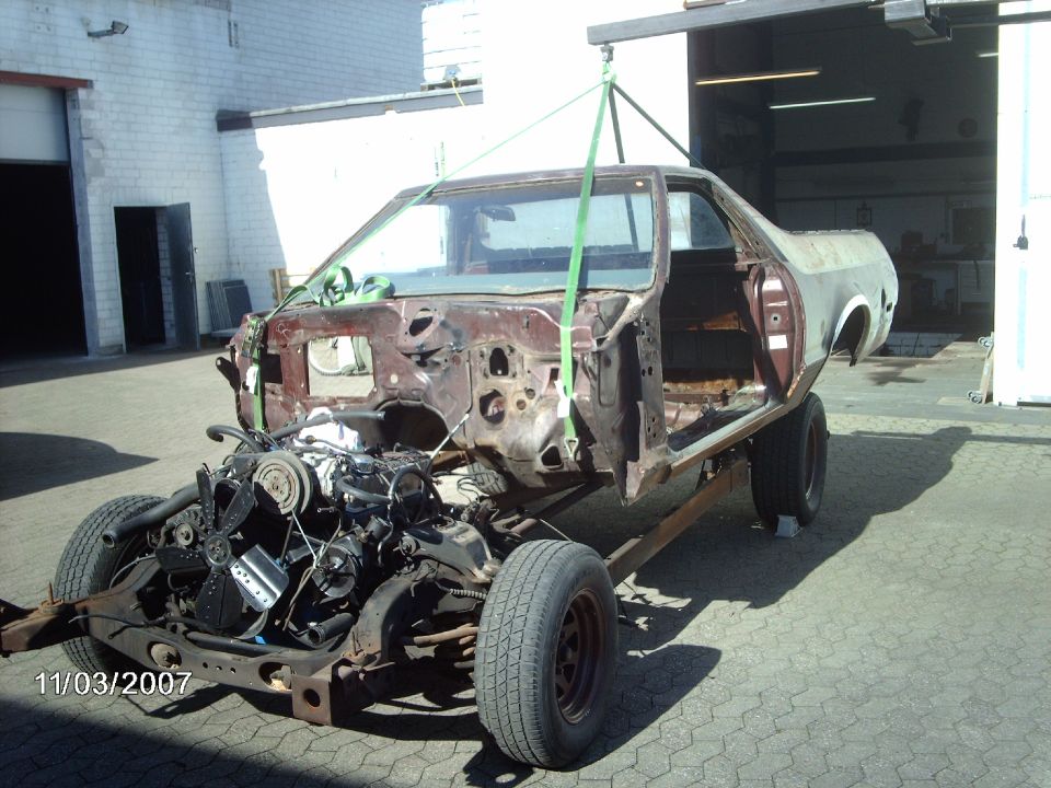 car body with engine and chassis being lifted by a crane