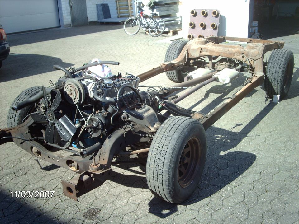 1979 Ford Ranchero chassis with engine, viewed from the front-left. The vehicle is disassembled and appears to be a project