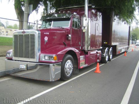 1968 Ford Mustang - A maroon Peterbilt semi-truck is parked on the side of the road, marked by orange traffic cones.