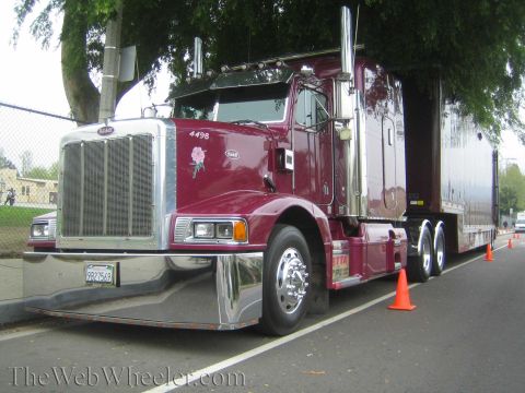 1968 Ford Mustang - A maroon Peterbilt semi-truck is parked on the side of the road, with orange cones marking its position.