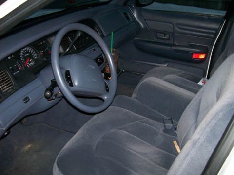 1999 Ford Crown Victoria - The interior of a 1999 Ford Crown Victoria, its dashboard, steering wheel, and cloth seats.