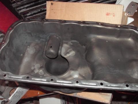 1989 Ford Probe - This is a close-up view of a used oil pan, showing signs of wear and tear.