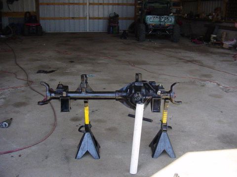1992 Ford Bronco - A vehicle's rear axle assembly is supported by jack stands in a workshop.