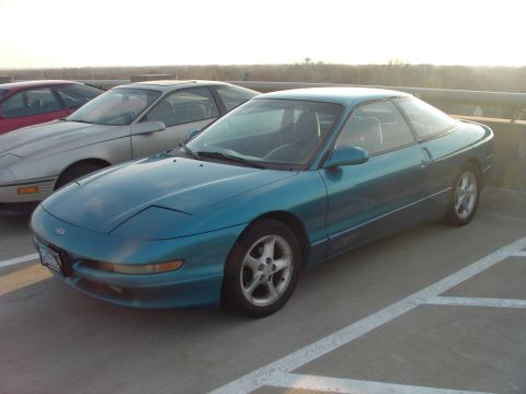 1989 Ford Probe - A teal 1989 Ford Probe coupe is parked in a lot with another vehicle visible.