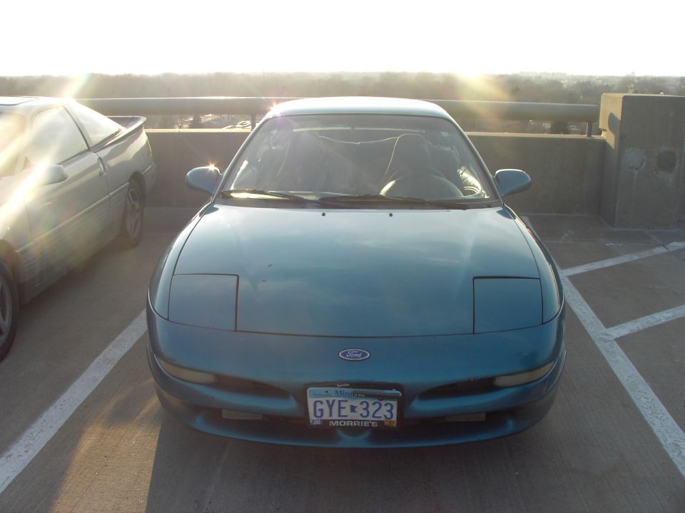 Teal Ford Probe parked next to another car, front view. License plate reads GYE 323