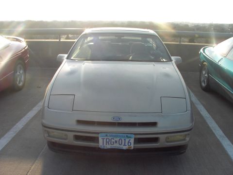 1989 Ford Probe - A 1989 Ford Probe is parked in a lot, with other vehicles visible on either side.