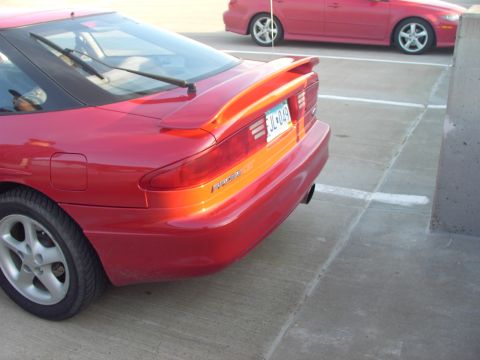 1989 Ford Probe - Rear quarter view of a red 1989 Ford Probe, parked in a lot with another vehicle visible.