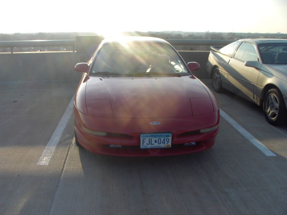 red 1989 Ford Probe parked next to a silver one on a sunny day