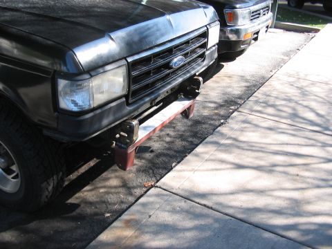 1991 Ford Bronco - Front view of a black Ford truck with a chrome grille and a custom bumper extension.
