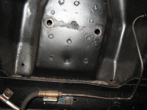 1968 Shelby GT500 - Detail of a car's undercarriage, likely a brake line assembly attached to a metal bracket.