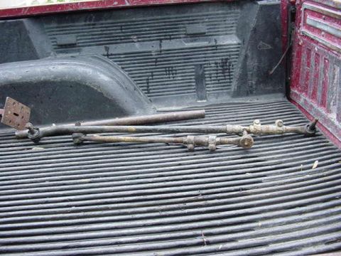 1992 Ford Bronco - Steering linkage parts are laid out in the bed of a pickup truck.