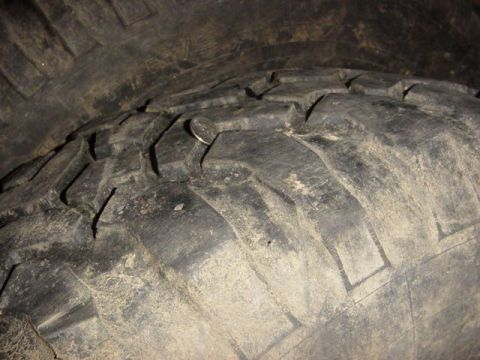 1992 Ford Bronco - A coin is lodged in the tread of a worn tire.