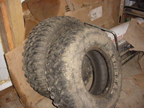 1992 Ford Bronco - Two off-road tires are shown stacked, with one tire's sidewall clearly displaying the brand name.