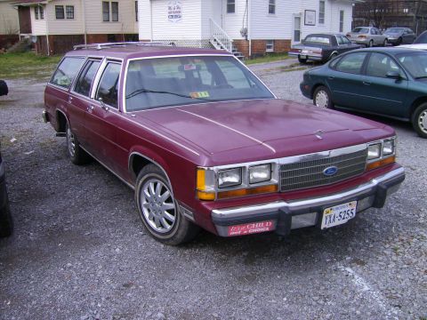 1982 Ford LTD Crown Victoria - This 1982 Ford Crown Victoria LTD station wagon is seen in a gravel lot with other vehicles in the background.
