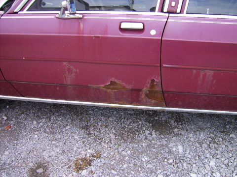 1982 Ford LTD Crown Victoria - The lower section of this car's door shows extensive rust and corrosion.