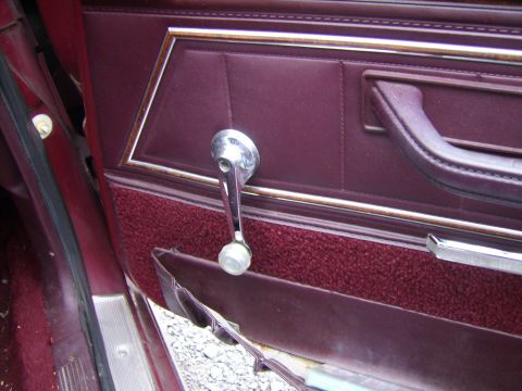 1982 Ford LTD Crown Victoria - The interior door panel shows a manual window crank and a torn fabric section near the bottom.