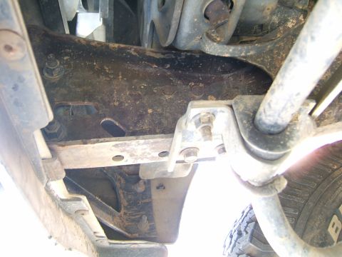 1991 Ford Bronco - Underside view of frame and suspension components, with a tire visible at the bottom right.