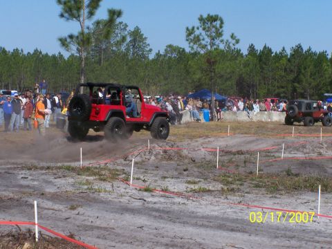 1989 Ford Bronco - A red Jeep Wrangler navigates a dirt course during an event in 2007.