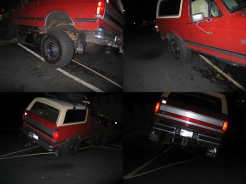 1987 Ford Bronco - This red 1987 Ford Bronco is parked at night, with its white top and roof rack visible.