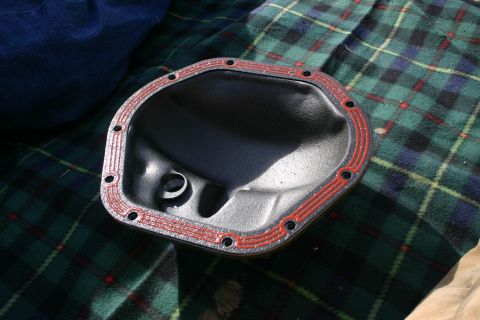 2003 Jeep TJ - A differential cover with red gasket sealant is shown on a plaid blanket.