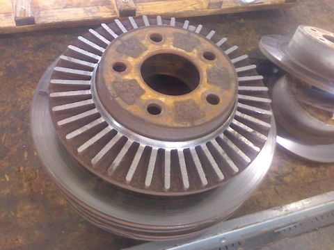 1995 Ford Bronco - A close-up view of several brake rotors, with one prominent cooling fins.