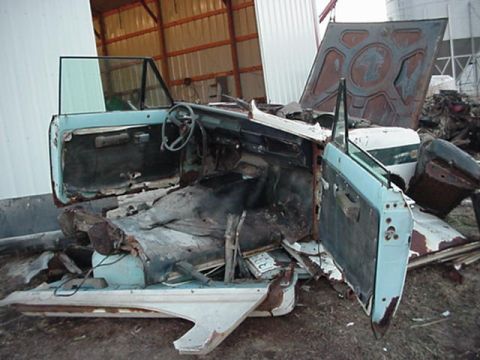 1992 Ford Bronco - The interior of a heavily damaged International Scout II is visible, with its doors removed and seats in disrepair.