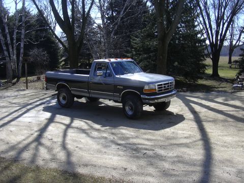 1992 Ford F-250 - A two-tone 1992 Ford F-250 pickup truck is parked outdoors on a sunny day.