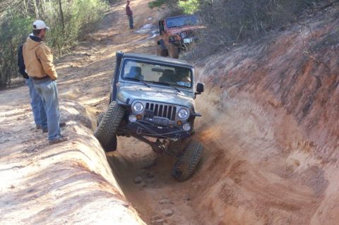 2004 Jeep Wrangler - Jeep Wrangler tackling an off-road trail, with another vehicle in the background.