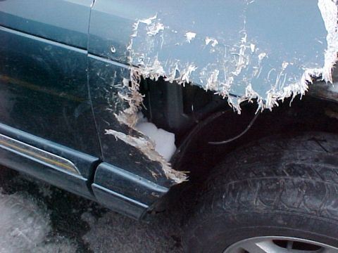 1978 Ford Mustang II - The vehicle's fender is severely damaged, showing peeling paint and underlying material.
