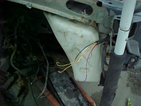 1978 Ford Mustang II - Close-up view of a wiring harness and a white fluid reservoir in an engine bay.