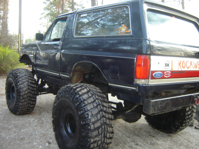 Rear view of a lifted 1989 Ford Bronco with large off-road tires and 'ROCKWELL' decal