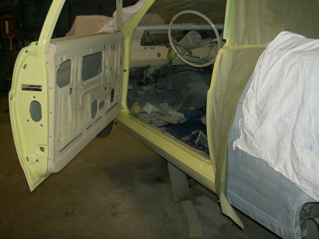 Interior of a yellow 1967 Ford Ranchero with door open, undergoing restoration