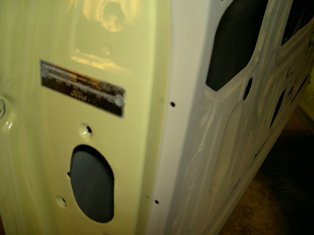 Yellow car door interior with Ford VIN plate and cutouts