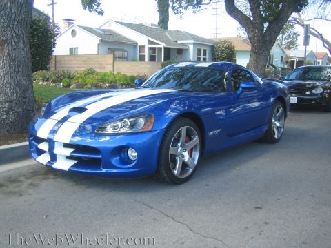 1968 Ford Mustang - A blue Dodge Viper with white stripes is parked on a street in front of houses.