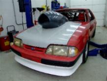 1990 Ford Mustang - Modified 1990 Ford Mustang set up for drag racing, a prominent hood scoop.