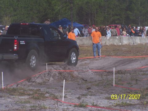 1989 Ford Bronco - A black Nissan pickup truck maneuvers through a dirt obstacle course during an event in 2007.