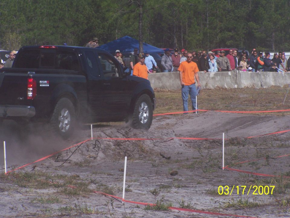 Black Nissan pickup truck navigating an off-road course