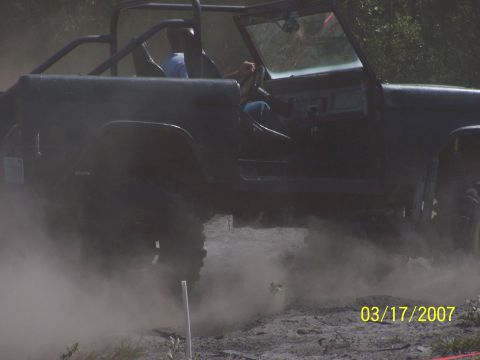 1989 Ford Bronco - A Ford Bronco is seen driving off-road, kicking up a cloud of dust.
