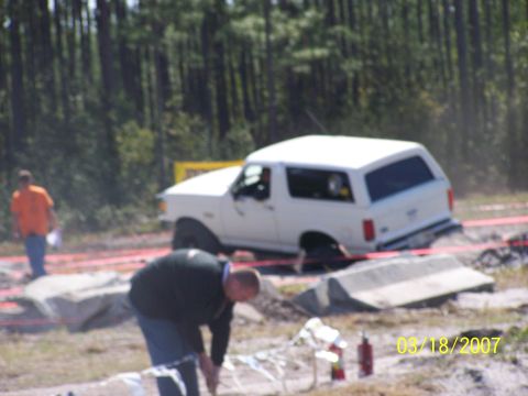 1989 Ford Bronco - A white 1989 Ford Bronco is stuck in the dirt during an off-road event.