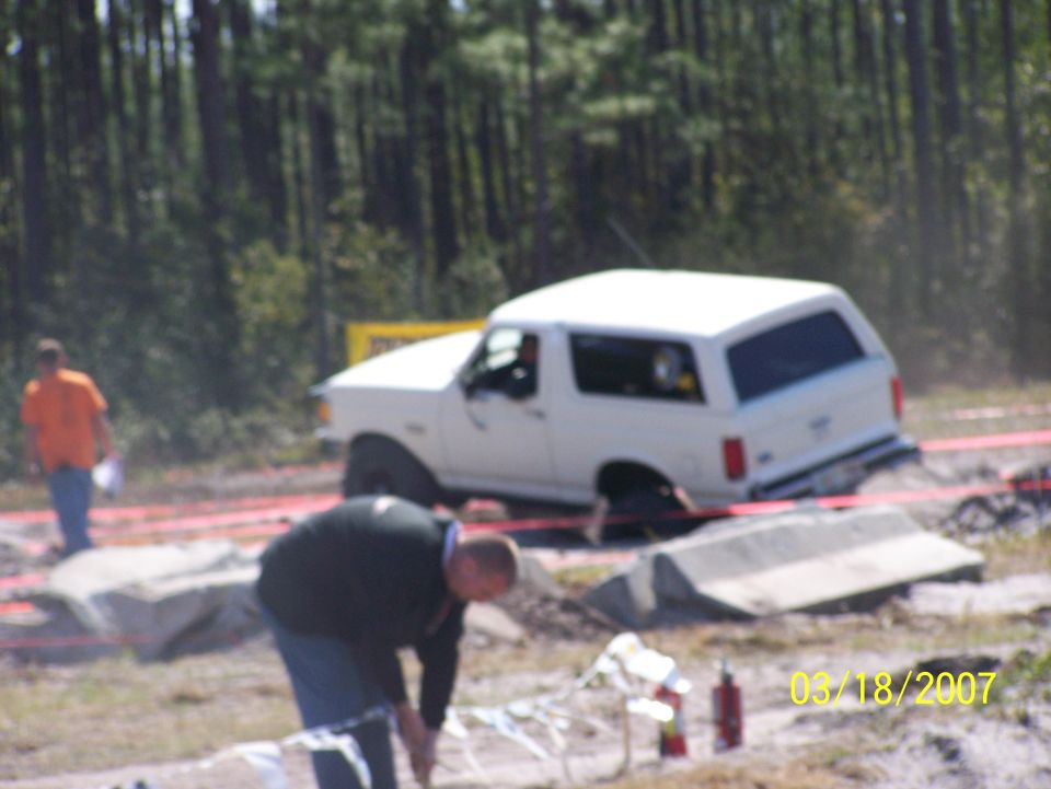 White 1989 Ford Bronco stuck in dirt, rear-wheel drive