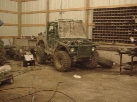 1992 Ford Bronco - An off-road vehicle is undergoing modifications in a cluttered garage setting.